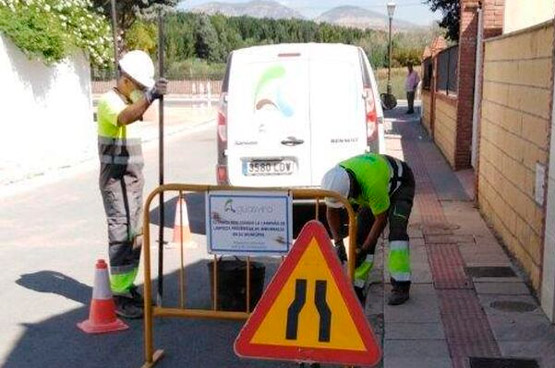 Operarios realizan labores de limpieza en un imbornal.